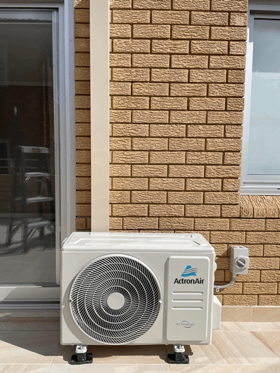 ActronAir outdoor air conditioner compressor unit installed on a brick wall by MyTradie Services Sydney