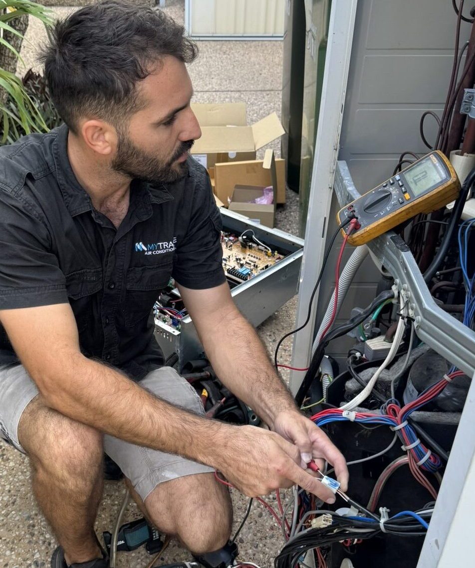 MyTradie Air Conditioning technician testing electrical components with a multimeter during an air conditioning repair service in Sydney